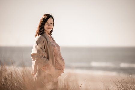 gravid dame på stranden fotografering