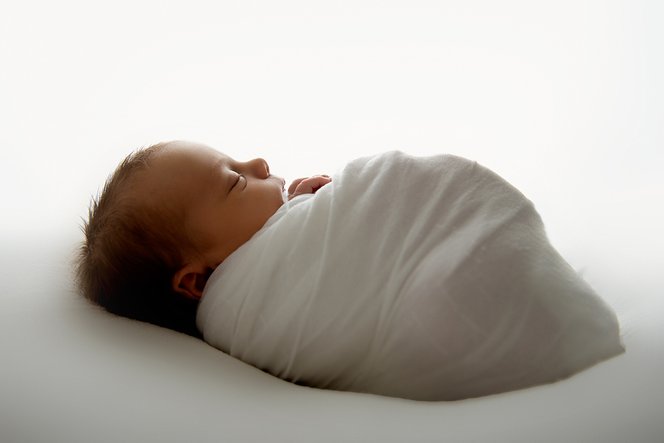 nyfødt baby i hvit wrap